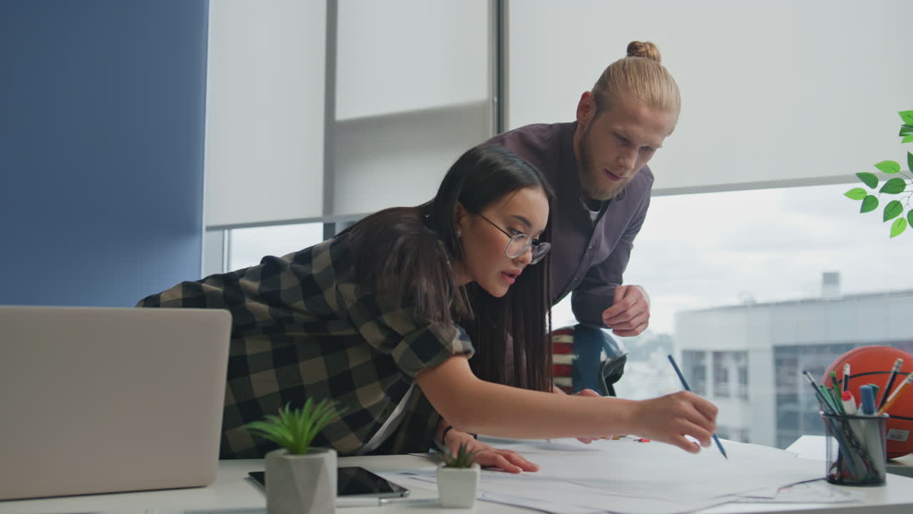 una pareja de arquitectos dibujando un boceto de un apartamento de cerca. dos diseñadores discutiendo el plan