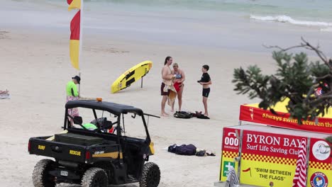 lifeguard vehicle and beachgoers on sandy shore