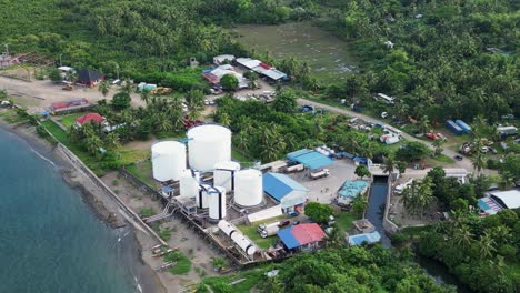 aerial overview of coastal fuel depot surrounded by lush foliage in tropical island of catanduanes, philippines during daytime