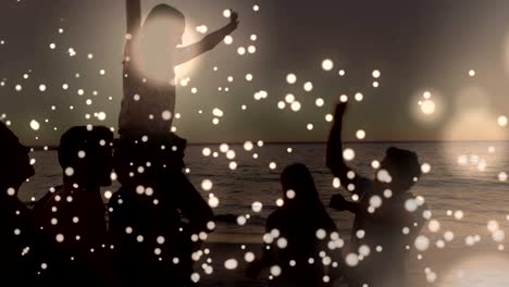 white glowing spots moving against group of friends partying on the beach