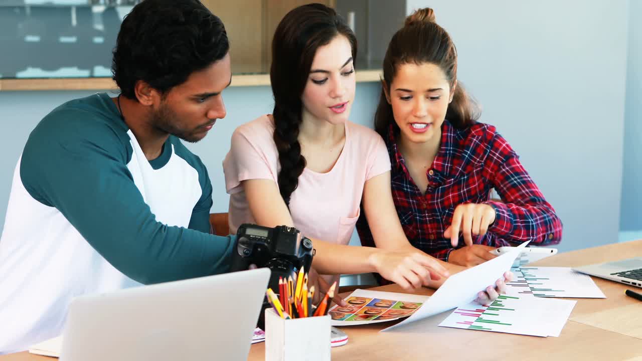 grupo de diseñadores gráficos trabajando juntos en un escritorio