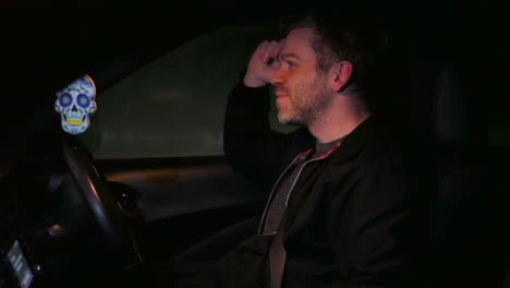 a man singing in his car listening to music on the radio at night