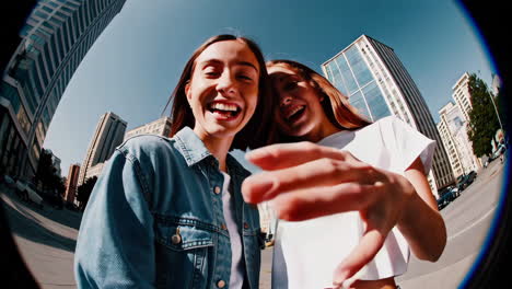joyful fisheye selfie of two friends in the city
