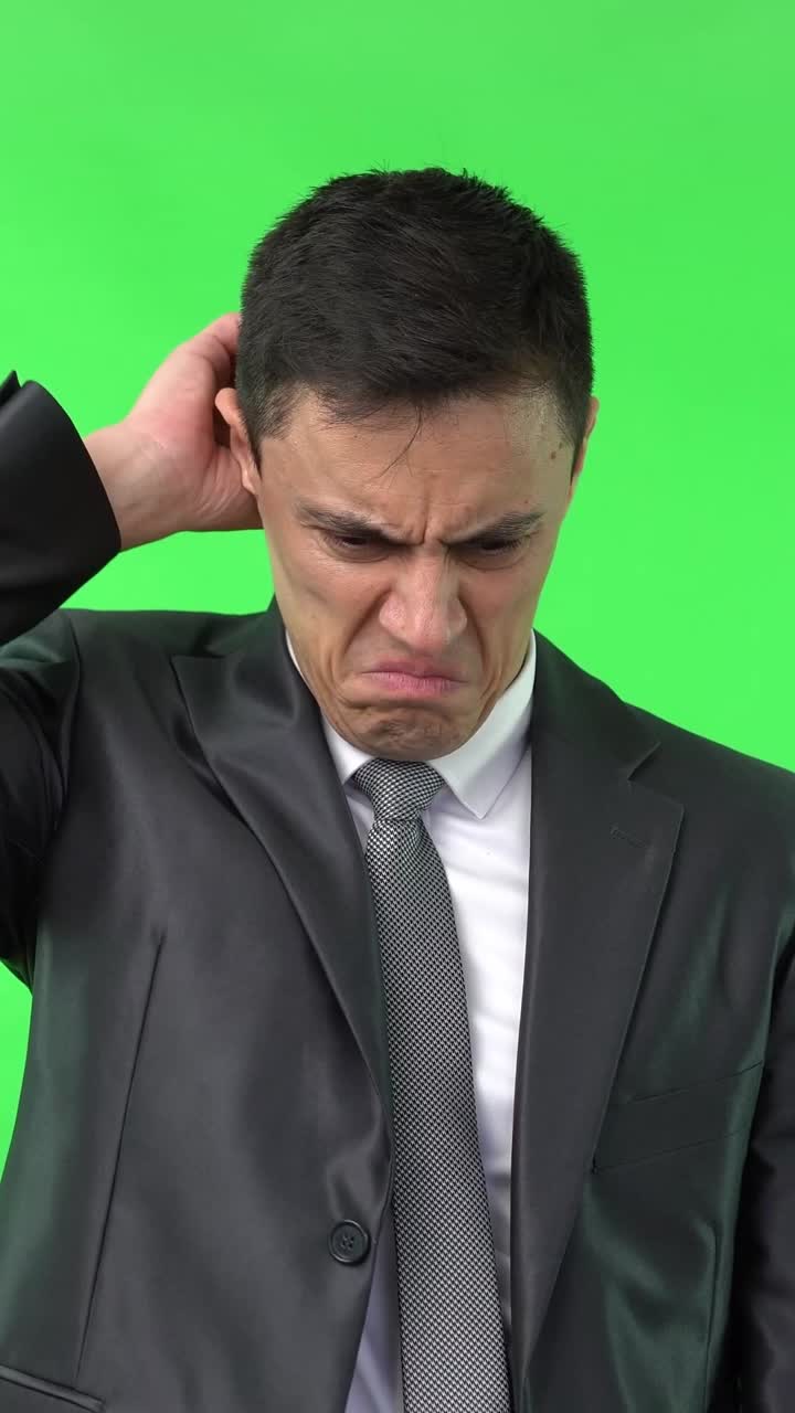 Uomo in abito che esprime disgusto o disagio su green screen