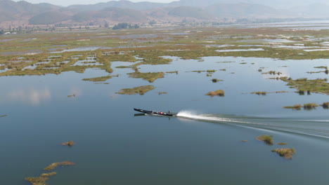 Single-Traditional-Longtail-Boat-on-Moebyel-Lake,-Myanmar,-Wide-Side-Angle-Tracking-Shot