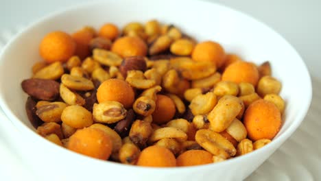 hand reaching into a bowl of mixed nuts