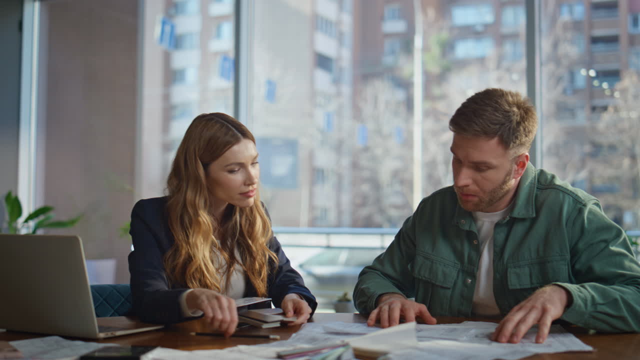 Designer proposing material samples to man client in office workplace closeup