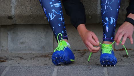 Close-up-of-female-athlete-tying-shoes-at-sport-venue-4k