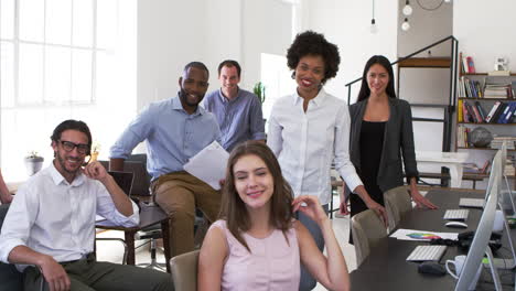 young business colleagues smiling to camera in their office