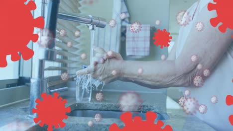 animation of covid 19 cells over senior caucasian woman washing her hands