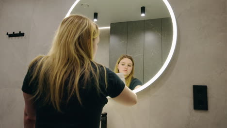 woman cleaning a bathroom mirror