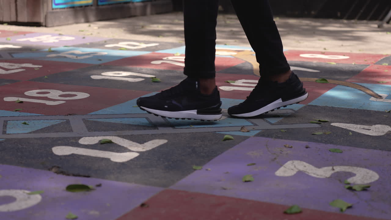 persona saltando hop scotch afuera