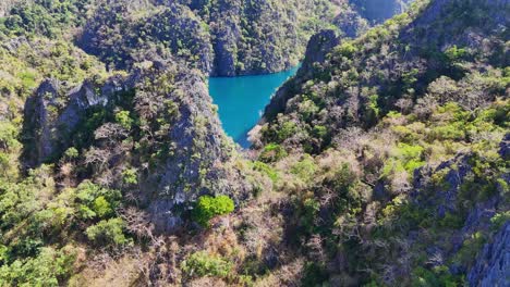 drone footage of cliffs revealing a lake on coron island in the philippines