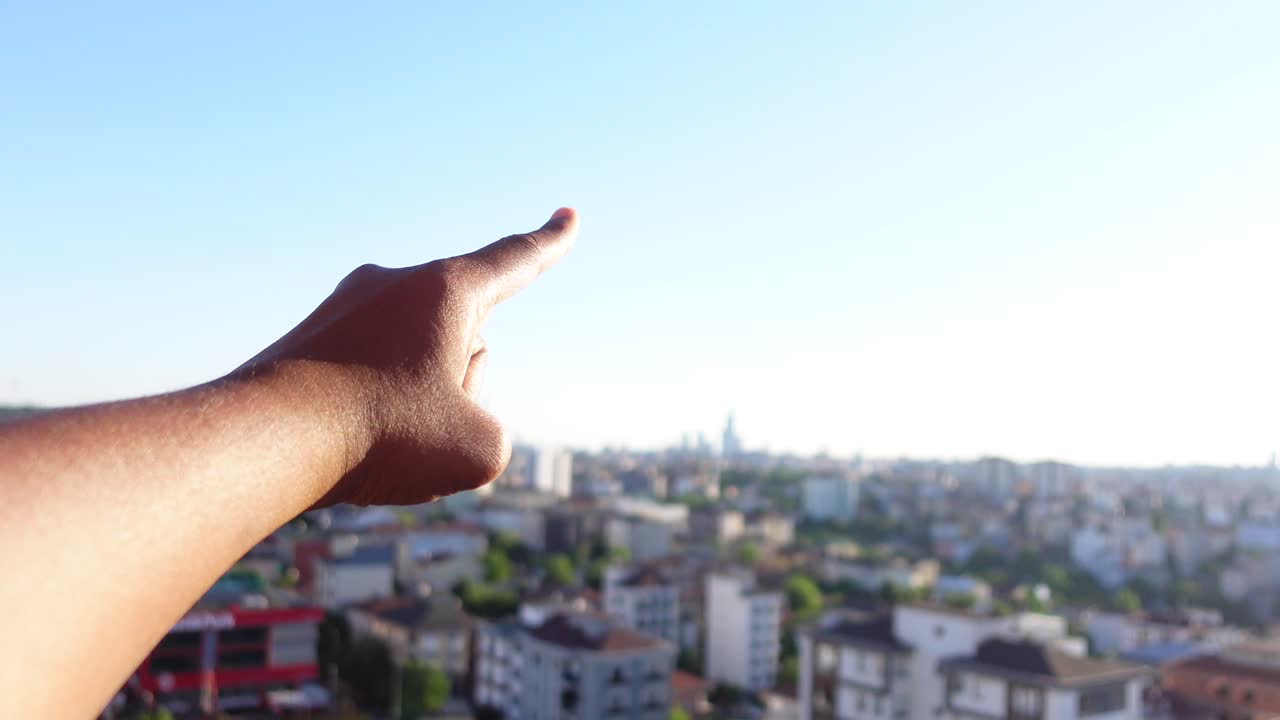 mano apuntando hacia un paisaje urbano