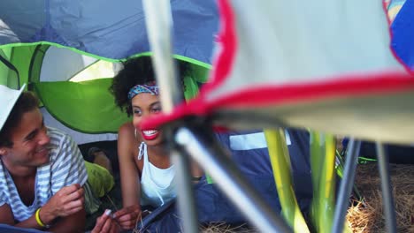 Pareja-Acostada-En-Una-Tienda-De-Campaña-Escuchando-Música-En-Un-Festival-De-Música-4k