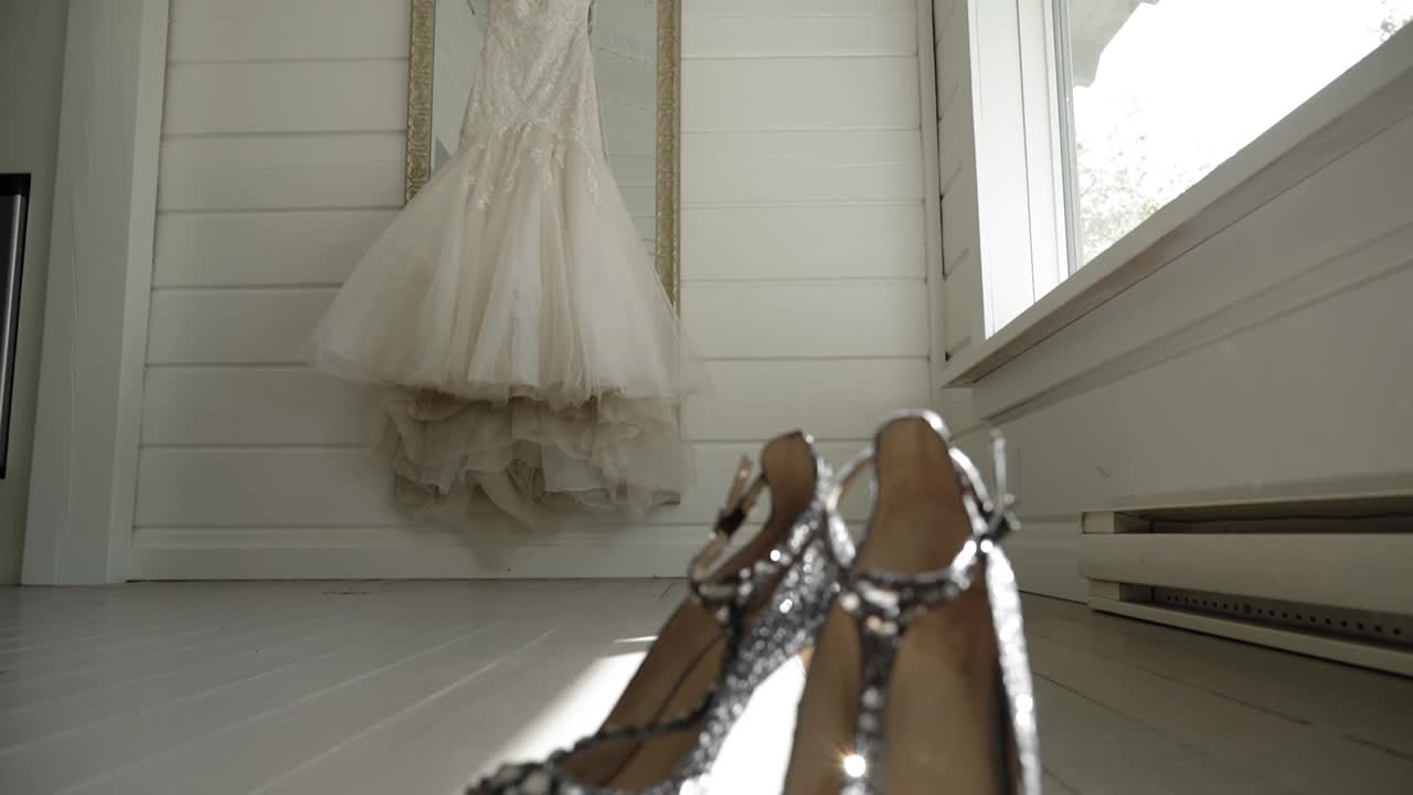 revelación de un par de tacones de cristal desde la vista de un elegante vestido de novia en una habitación blanca en le belvédère en wakefield, quebec, canadá