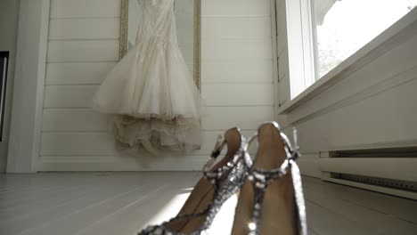 Revelación-De-Un-Par-De-Tacones-Altos-De-Cristal-Desde-La-Vista-De-Un-Elegante-Vestido-De-Novia-En-Una-Habitación-Blanca-En-Le-Belvédère-En-Wakefield,-Quebec,-Canadá