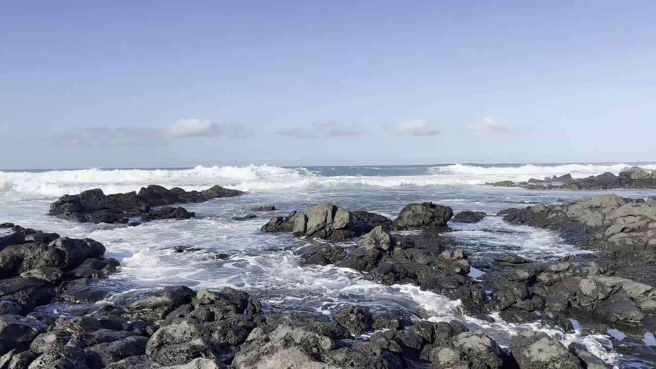 una escena dinámica de olas que se estrellan contra la escarpada costa rocosa de oahu, hawai,