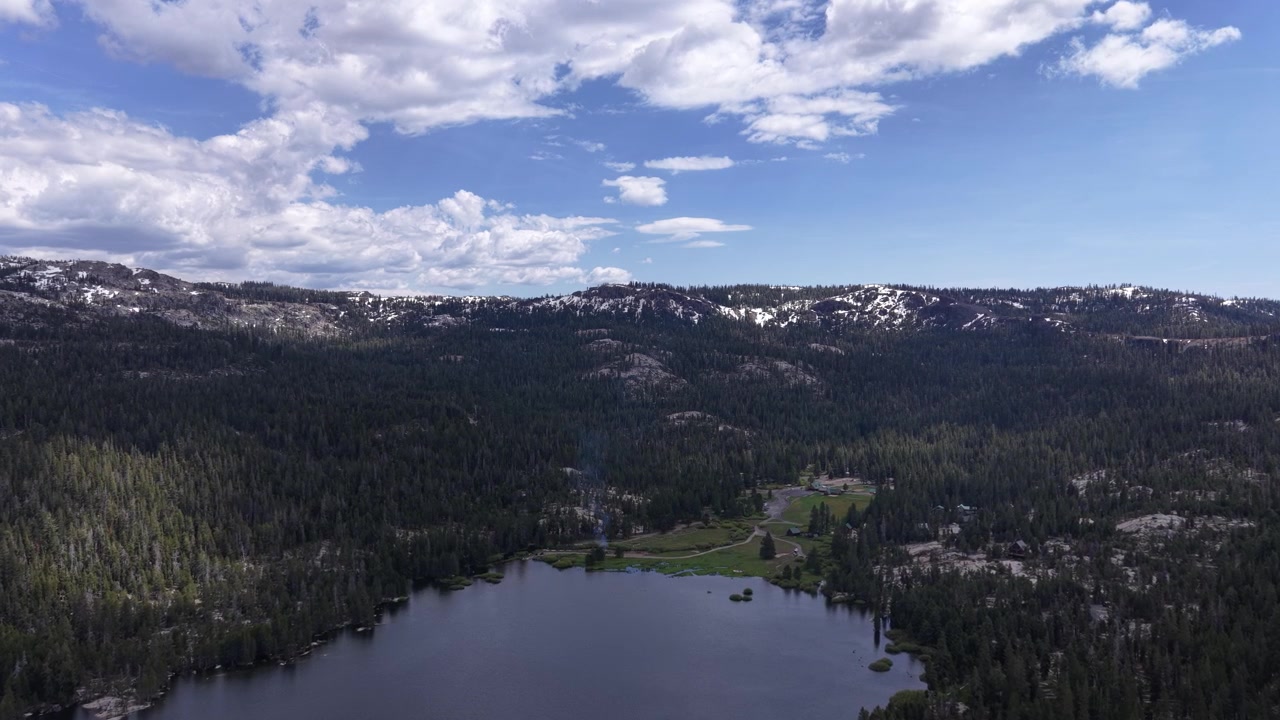 Ripresa con drone in avvicinamento sopra Silver Lake, California, che rivela acque calme, il terreno circostante e un vasto paesaggio naturale. La prospettiva elevata mostra il carattere pacifico della zona e l'ambiente esterno.