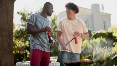 grilling food, two multiracial male friends smiling and enjoying drinks at outdoor barbecue