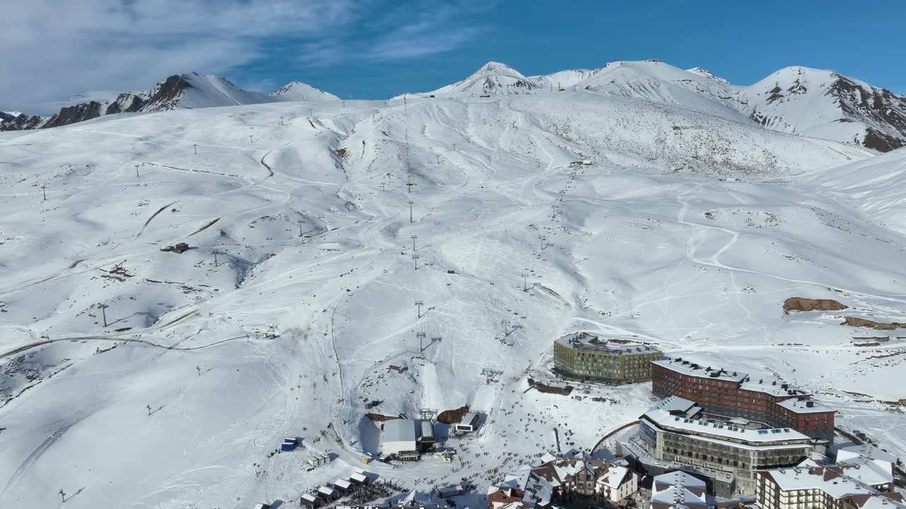 A breathtaking panoramic view of wide, untouched snowy slopes stretching across majestic mountain ranges, perfect for skiing and snowboarding enthusiasts