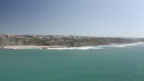 birds view from the coastline of ericeira with village in the background