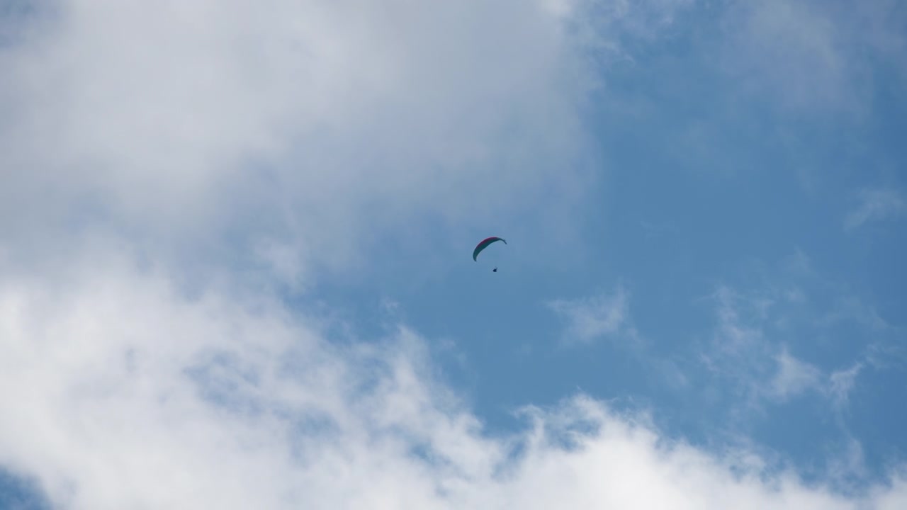 Paesaggio nuvoloso con un parapendio in volo.
