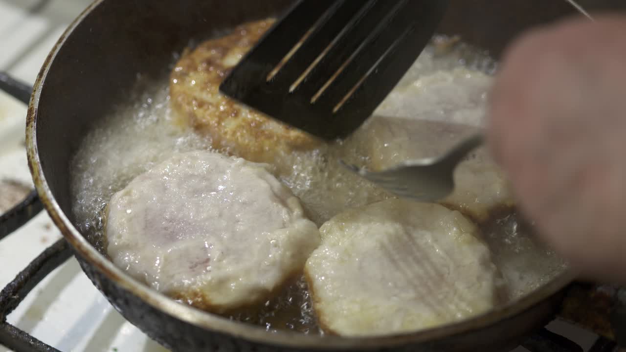 집에서 만든 긴 생선 햄버거 패티. 뜨거운 기름으로 생선 패티를 는 것