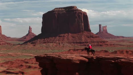 Long-Shot-Of-A-Cowboy-Riding-His-Horse-To-Vista-Overlook-In-Monument-Valley-Arizona