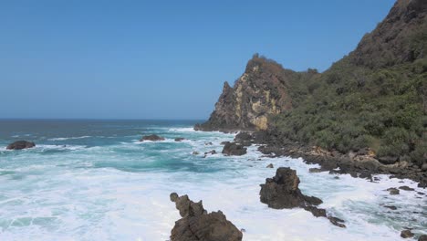 Shots-flying-backwards-over-the-ocean-surf-on-the-rocky-coast-of-Indonesia