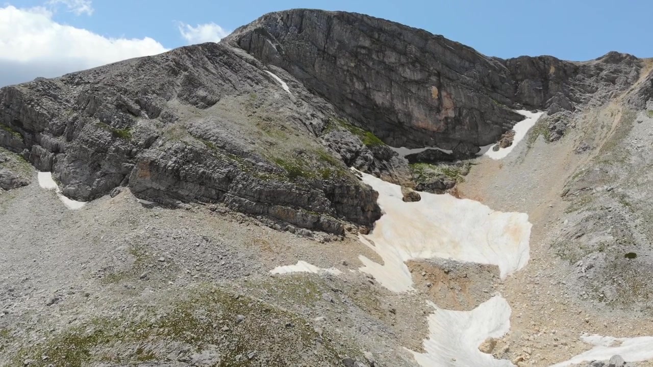 Vista aerea di una vetta montuosa rocciosa con chiazze di neve