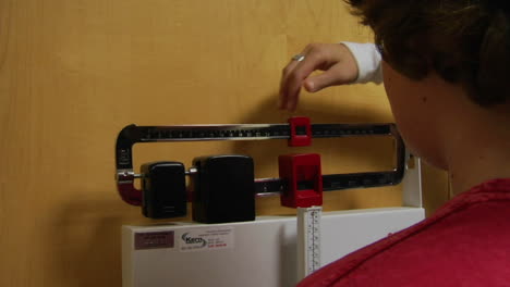 a nurse weighs a patient on a doctor office scale