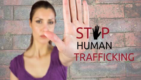 animation of stop human trafficking text over caucasian woman with stop gesture