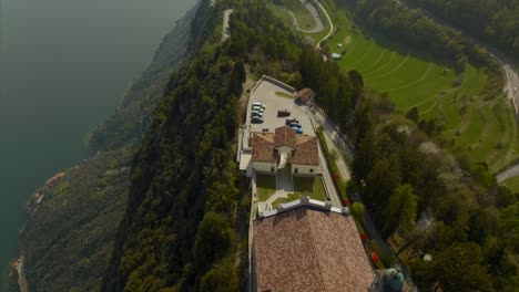 cinematic aerial dolly of scenic hilltop village comune and sanctuary of montecastello overlooking lake garda and forest trails