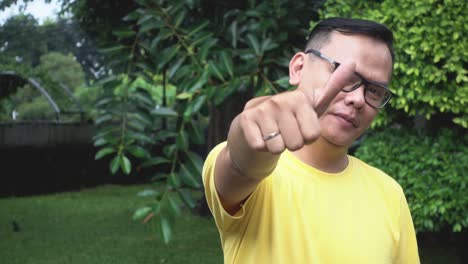 positive young man showing thumb up and smiles to camera