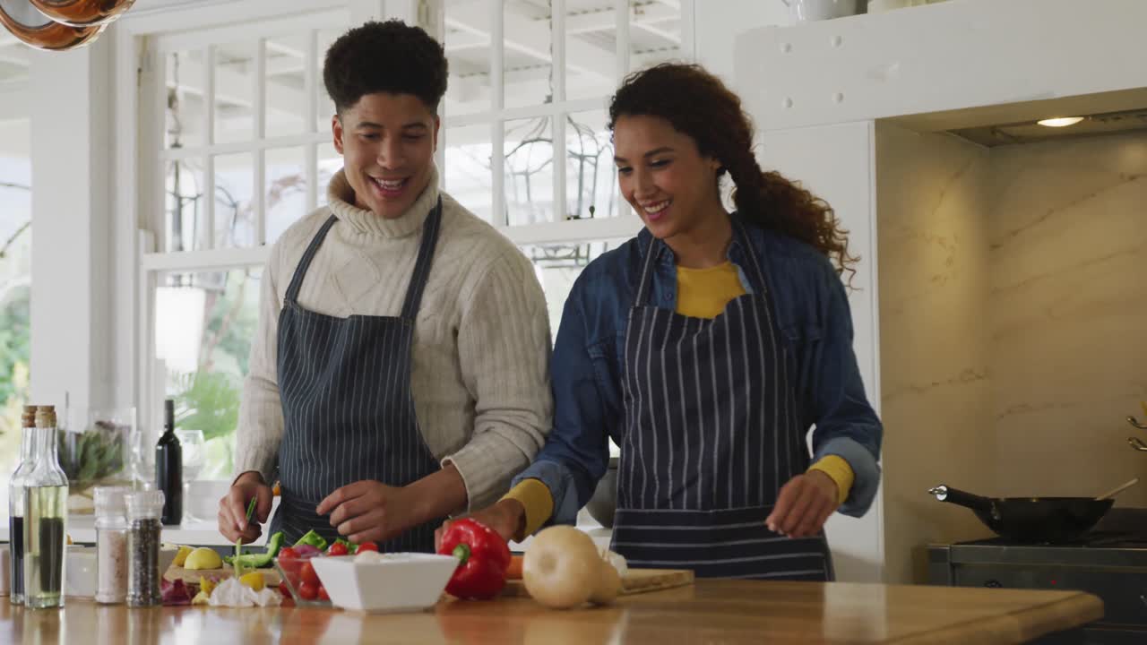 video de una feliz pareja biracial preparando una comida juntos