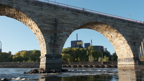 stone arch bridge framing historic guthrie theater on a bright clear morning