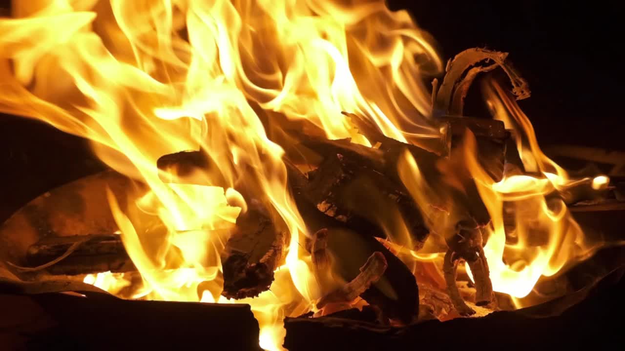 slow motion flames burn wood on a camp fire