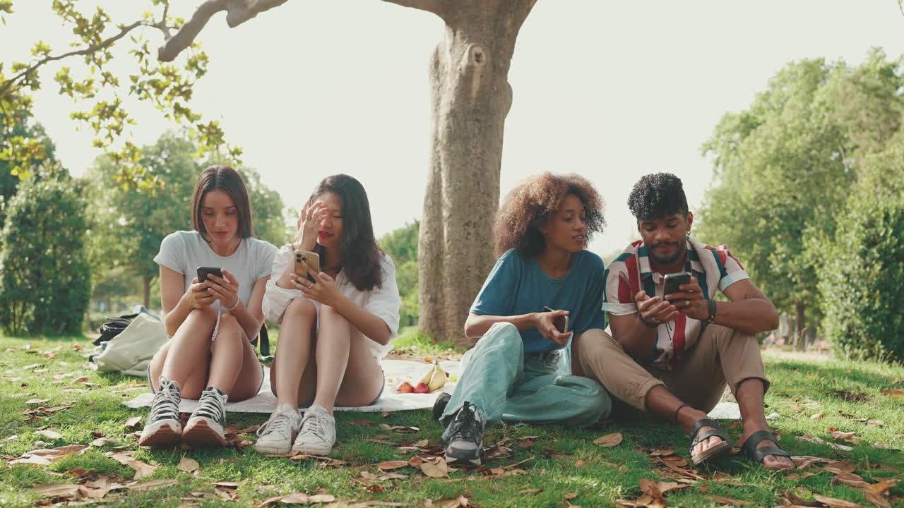 Gruppo di amici che usano i cellulari nel parco
