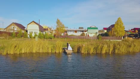 pareja feliz se encuentra en el muelle del río en un día soleado aérea