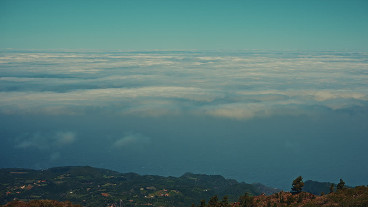 Aerial view of a dramatic landscape with clouds, ocean, and mountains