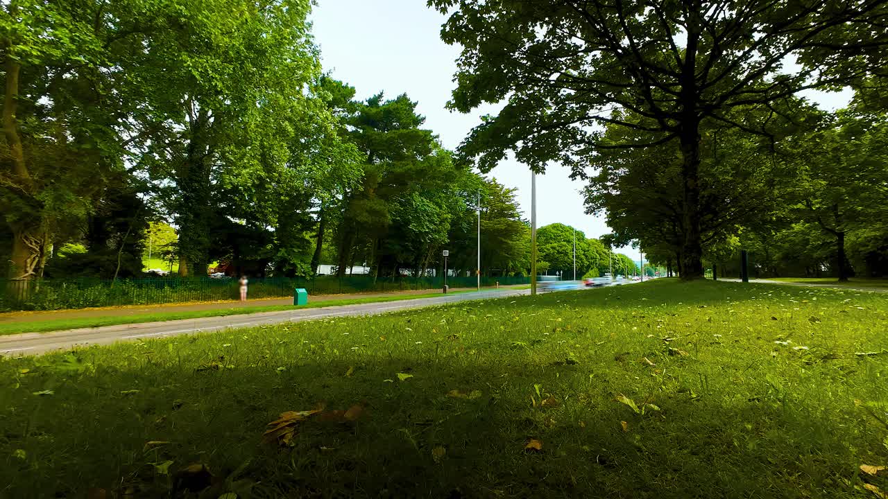 Long Exposure Timelapse of Cars Moving Fast Past Wide Angle Camera in City Center Park. Cars and Buses Modern Transportation Commuting Footage. Cycling and Cars with Green and Polluting Commutes