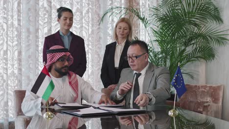 diplomats from different countries signing papers during negotiations