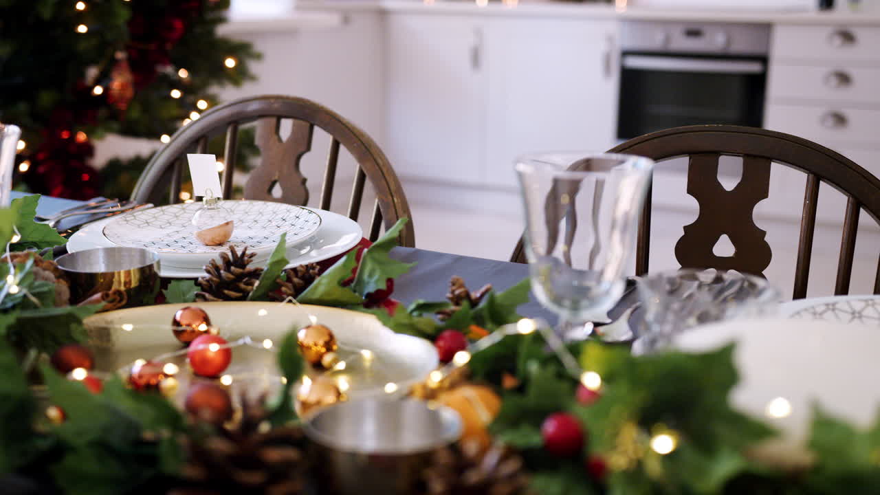 sección media de una mujer colocando cubiertos en un lugar sentado en una mesa de comedor decorada para la cena de navidad, enfoque selectivo