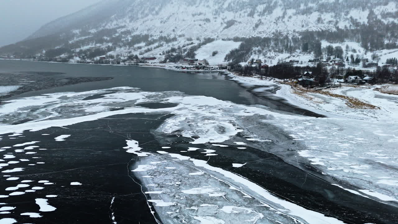 Frozen fjord in Tromsø, Norway, with icy water, snow-covered mountains, and winter vibes