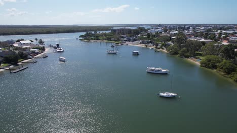 aerial view of boats on a sunny river in a coastal town