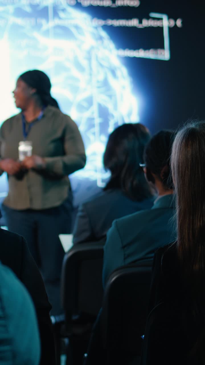 Vídeo vertical de jovem adulto levantando a mão para fazer perguntas ao palestrante negro no palco