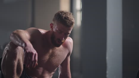 hombres jóvenes agotados descansando después de un entrenamiento intensivo en el gimnasio. fitness hombre saludable cansado después de un ejercicio de entrenamiento de fuerza en el gimnasio. hombre cansado modelo en forma con estar de pie y relajarse después de un entrenamiento intenso.