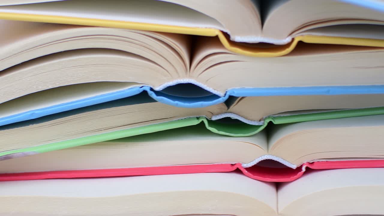 Desk with stack of open study books. Textbooks for the student, university. Study from home. Distance education concept.
