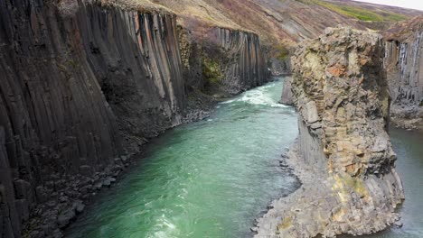 aerial view of fast streaming water in a steep canyon in iceland on a sunny day